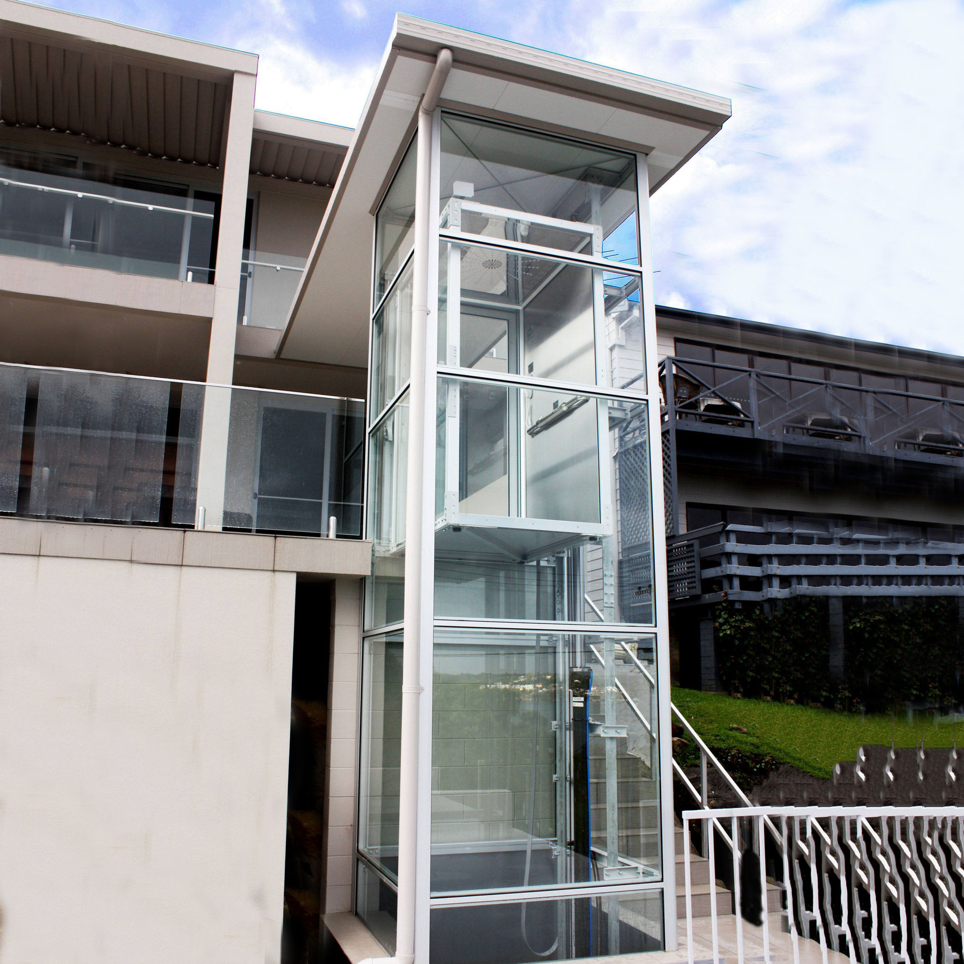 Outdoor home elevator enclosure installed on a modern house exterior