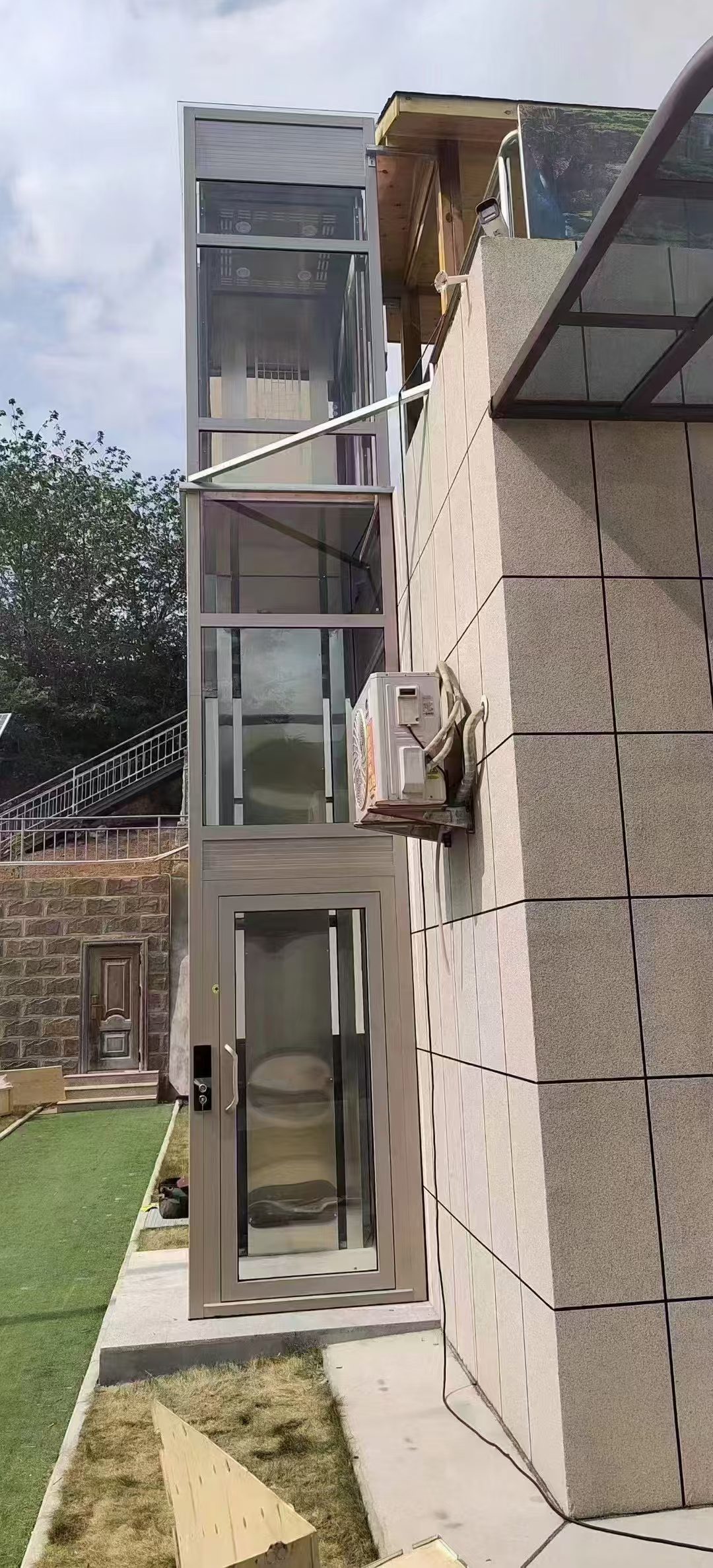 Three-storey outdoor glass home elevator installed on a building exterior