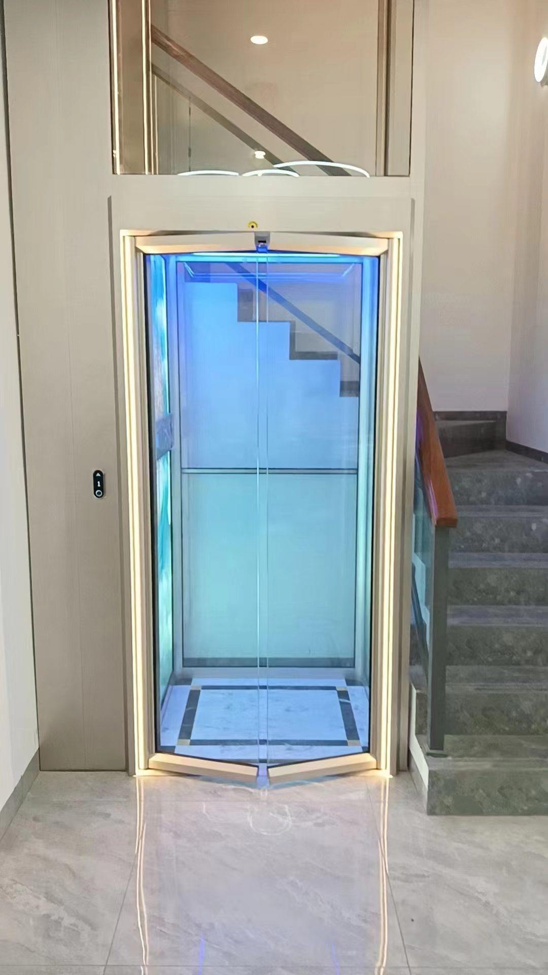 Home elevator with wide glass entrance doors next to a staircase